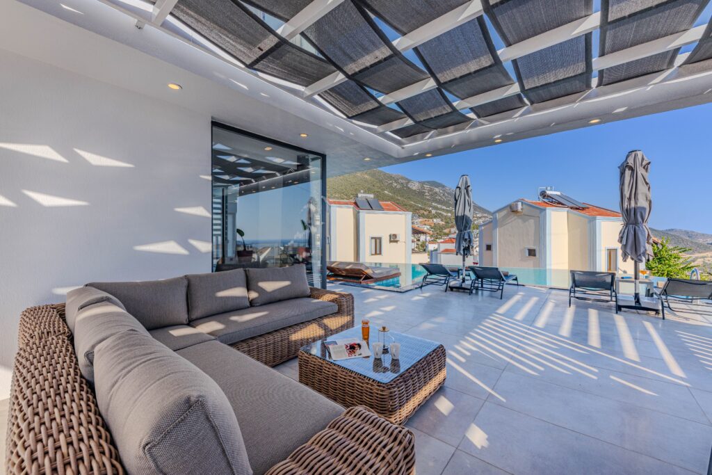Luxurious outdoor terrace with seating, overlooking mountains and a pool.